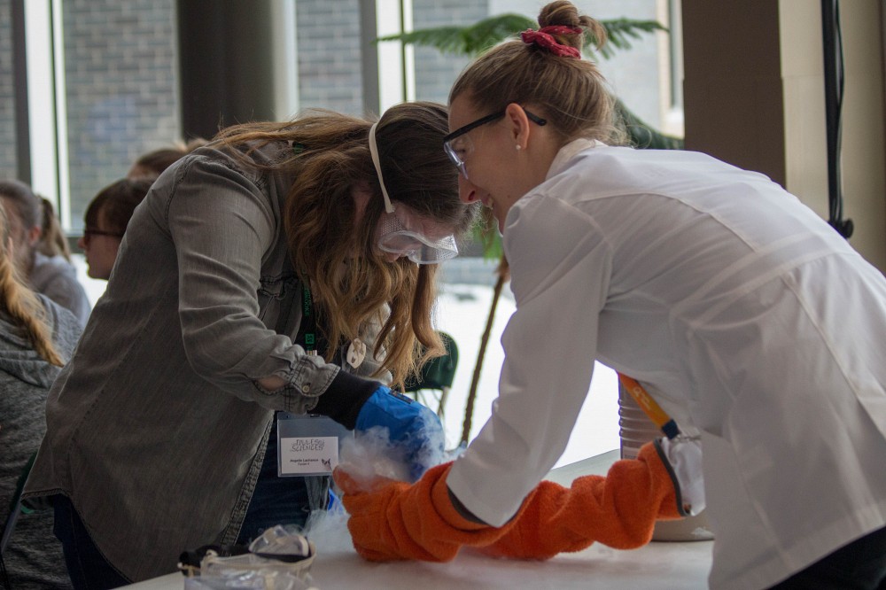 Une participante pr&eacute;pare sa cr&egrave;me glac&eacute;e &agrave; L'azote liquide avec l'aide d'Apolline Benoist.
