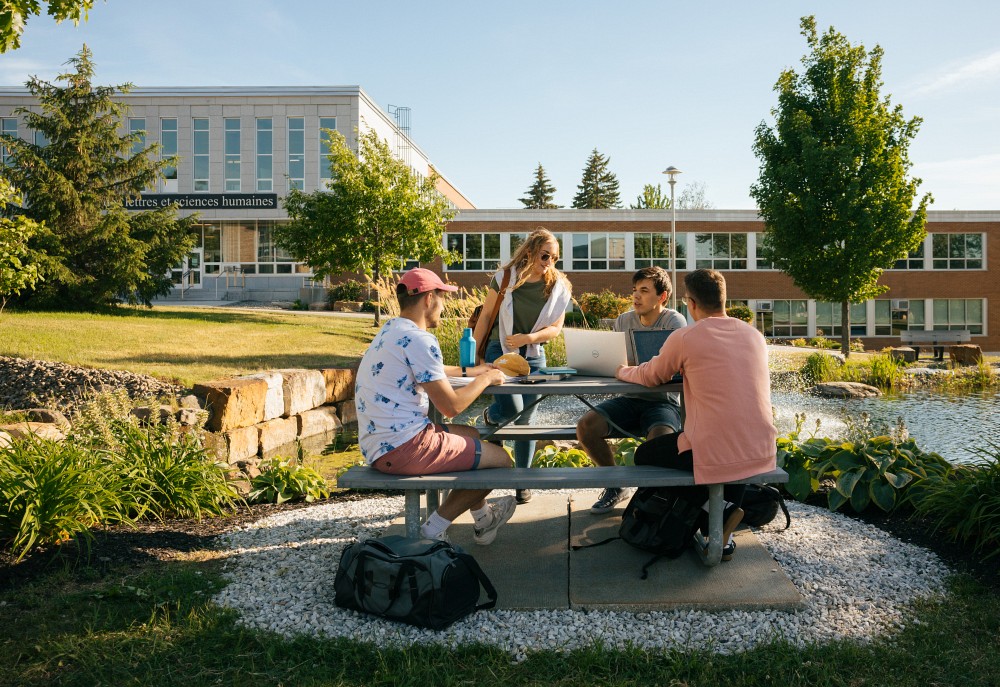 Des personnes &eacute;tudiantes devant la Facult&eacute; des lettres et sciences humaines de l'Universit&eacute; de Sherbrooke.