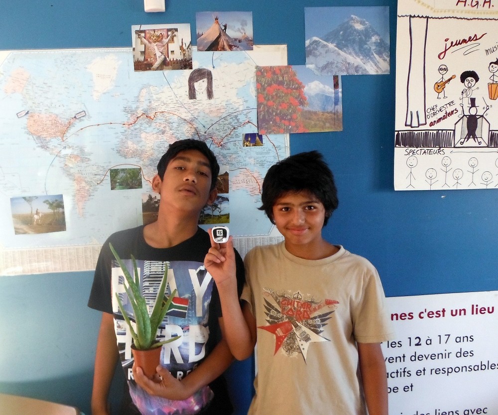 Les deux jeunes participants de la Maison des jeunes, avec la plante alo&egrave;s re&ccedil;ue &agrave; la soir&eacute;e th&eacute;matique Johannesburg et le podom&egrave;tre fourni par l'UdeS.