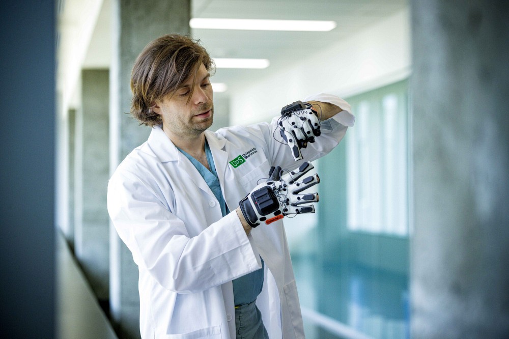 Le Pr Christian Iorio-Morin manipulant le gant haptique.