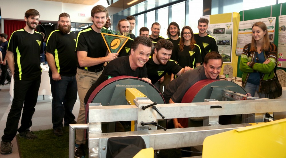 Le professeur Patrik Doucet, doyen de la Facult&eacute; de g&eacute;nie, d&eacute;montre toute sa force en utilisant la machine con&ccedil;ue et fabriqu&eacute;e par le projet SAMUS, coup de coeur du public de la 3e &eacute;dition de la M&eacute;gaG&Eacute;NIALE.