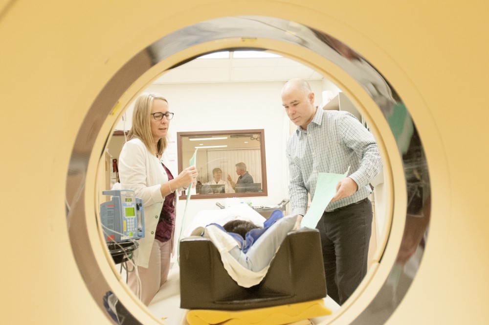 Denis Blondin, stagiaire postdoctoral, est en train de pr&eacute;parer le patient. Le Pr Andr&eacute; Carpentier (derri&egrave;re la fen&ecirc;tre) est en discussion avec les membres de son &eacute;quipe de recherche.
