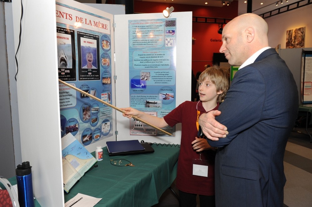 Olivier Blais, r&eacute;cipiendaire du Premier prix Hydro-Qu&eacute;bec pour son projet &laquo;&nbsp;Les dents de la m&egrave;re!&nbsp;&raquo;&nbsp;pr&eacute;sente son projet au pr&eacute;sident scientifique de l'&eacute;v&eacute;nement, David Fortin, professeur &agrave; la Facult&eacute; de m&eacute;decine et des sciences de la sant&eacute; et neurochirurgien au Centre hospitalier universitaire de Sherbrooke.