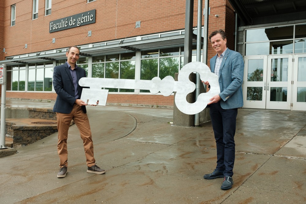 Le professeur Patrik Doucet, &agrave; droite, qui passe une symbolique cl&eacute; de 2 m&egrave;tres &agrave; son successeur, le professeur Jean Proulx!