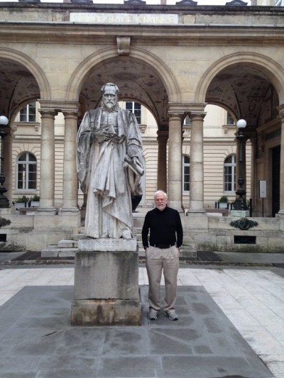 Le Pr Andr&eacute;-Marie Tremblay dans la cour du Coll&egrave;ge de France, &agrave; c&ocirc;t&eacute; de la statue de Guillaume Bud&eacute;, sous les conseils duquel Fran&ccedil;ois premier a fond&eacute; l'institution.