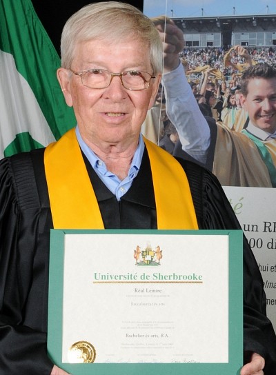 R&eacute;al Lemire arbore son parchemin officiel frapp&eacute; des nouvelles armoiries de l'UdeS.