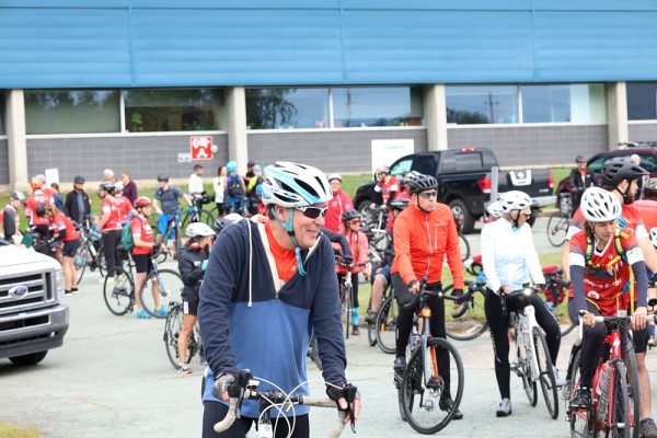 Jean-Pierre Perreault, vice-recteur de l'Universit&eacute; de Sherbrooke, entour&eacute; des participants cyclistes pr&ecirc;ts &agrave; partir pour r&eacute;aliser leur d&eacute;fi