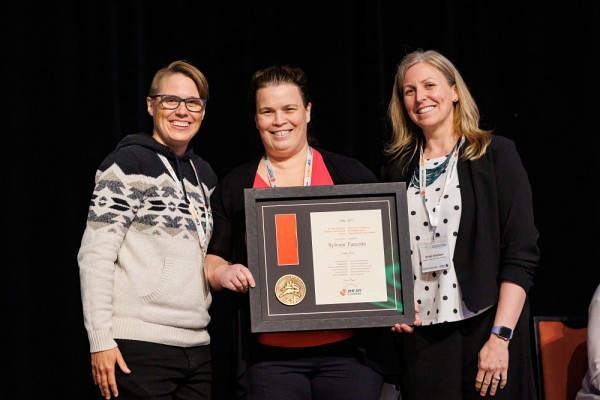 La professeure Sylvie Beaudoin au Congr&egrave;s national EPS Canada. Elle a pu accepter le prix au nom du professeur Sylvain Turcotte. Elle est accompagn&eacute;e par la professeure&nbsp;Joanna&nbsp;Sheppard, pr&eacute;sidente d'EPS Canada (&agrave; gauche) et madame&nbsp;Krista Smeltzer, repr&eacute;sentante du Qu&eacute;bec sur le Conseil de direction (&agrave; droite).&nbsp;