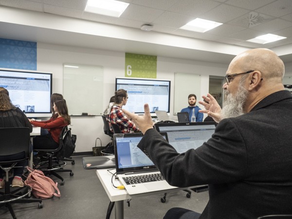 Dans cette salle d'apprentissage actif, le professeur se trouve au centre de la classe, et les &eacute;quipes d'&eacute;tudiantes et &eacute;tudiants sont autour de lui.