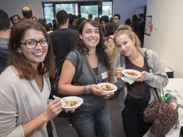 Des &eacute;tudiantes venues de l'international savourent une traditionnelle poutine lors de la soir&eacute;e de bienvenue.