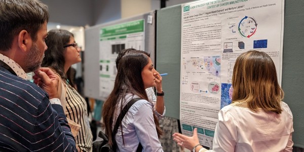 Des participantes et participants de l'&eacute;v&eacute;nement &eacute;coutent attentivement une pr&eacute;sentation vulgaris&eacute;e.