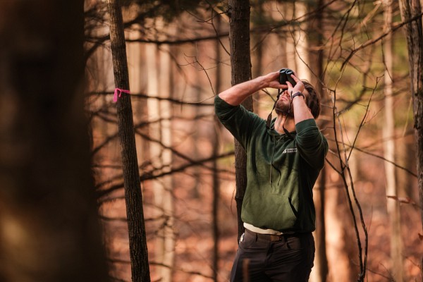 Les ateliers en nature permettent aux personnes &eacute;tudiantes de r&eacute;colter des donn&eacute;es qui m&egrave;neront &agrave; de vraies prises de d&eacute;cisions &agrave; l'&eacute;gard des milieux naturels &eacute;tudi&eacute;s. Ici, un &eacute;tudiant durant un atelier d'&eacute;chantillonnage sur les communaut&eacute;s aviaires foresti&egrave;res au mont Bellevue. 