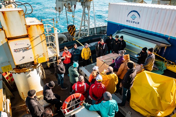 La professeure Gu&eacute;guen (de face, en jaune) sur le pont du NCSM Margaret Brooke, en discussion avec les autres &eacute;quipes contribuant &agrave; la mission CARE.
