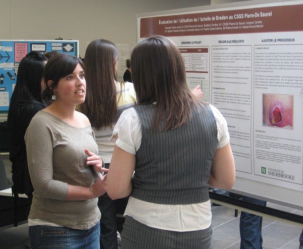 Une &eacute;tudiante explique le projet de son &eacute;quipe &agrave; une personne du public.