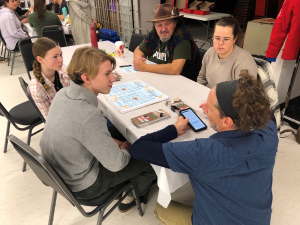 M. Guy Drouin discute avec Z&eacute;lia, Karim et Tania, sous le regard int&eacute;ress&eacute; de l'A&icirc;n&eacute; innu Gr&eacute;goire&nbsp;Canap&eacute;, lors de la Mini-&eacute;cole de m&eacute;decine et sciences de la sant&eacute; tenue dans la communaut&eacute; de Mashteuiatsh au Saguenay &ndash;&nbsp;Lac-Saint-Jean, &agrave; l'automne 2023, dans le but d'inciter les jeunes du secondaire &agrave; devenir des professionnelles et professionnels de la sant&eacute;.&nbsp;
