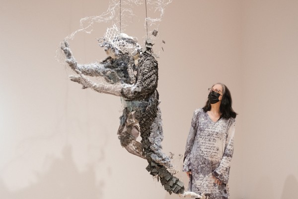 La professeure Christiane Lahaie, directrice du D&eacute;partements des arts, langues et litt&eacute;ratures &agrave; la FLSH, devant une sculpture de l'exposition.