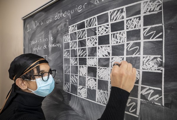 Assim Bousselsal, animateur au Cercle math&eacute;matique, pr&eacute;parant une &eacute;nigme au tableau.